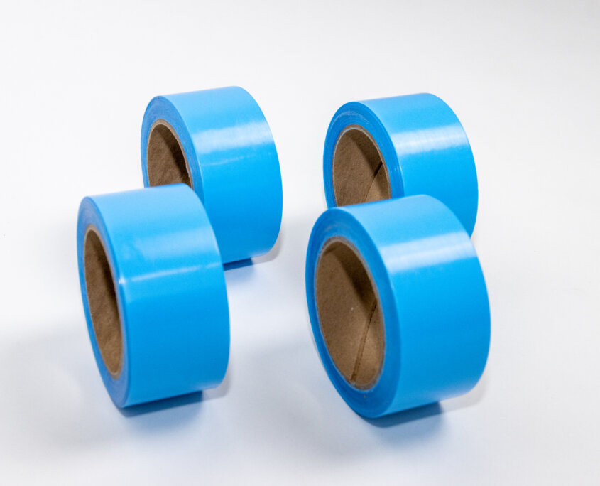 Roll of UHMW tape with low-friction surface and acrylic adhesive for reducing drag on chutes, guide rails, and sliding parts
