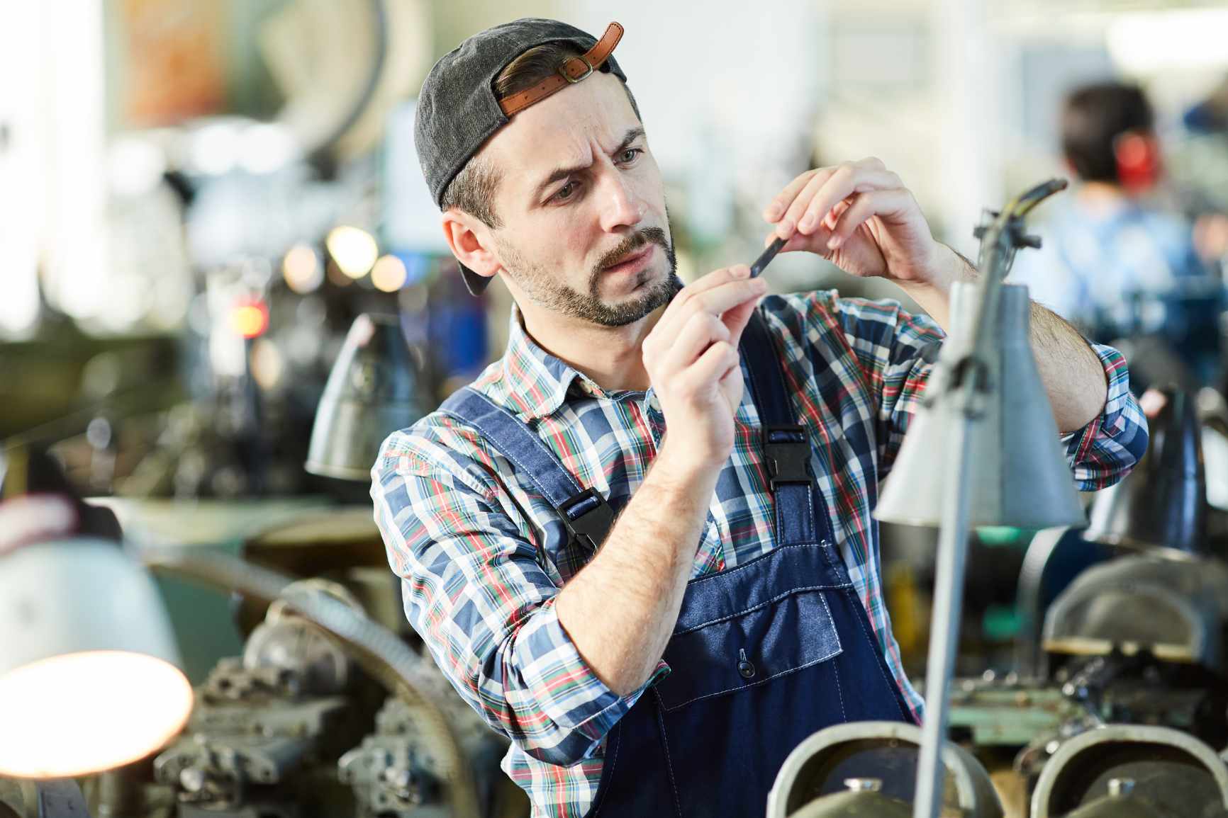 A male barber cutting a client's hair with scissors.