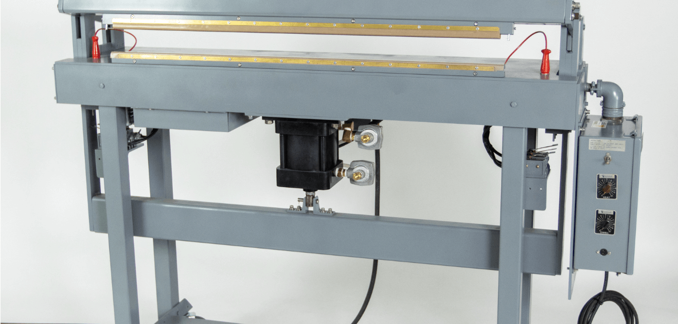 Industrial heat sealer machine on white background.